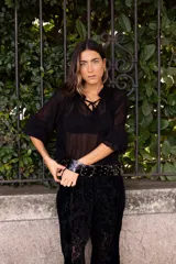 Blusa de plumeti color bordó, con cuello alto ajustable mediante lazo, mangas largas con puños elásticos y detalle de volados en las terminaciones.