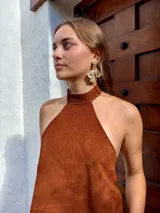 Caravanas colgantes de diseño floral con pétalos texturizados en tono dorado y detalles de pequeñas perlas en la parte superior.