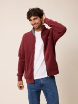 Campera de polar bordó con cierre frontal completo, cuello alto y puños elásticos. Presenta un diseño liso con logo bordado en el pecho.