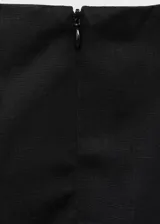 Vestido corto negro de corte evasé, confeccionado en mezcla de lino y lyocell. Presenta cuello barco, sin mangas con tirantes anchos, y detalle de pliegues en la falda. Cuenta con cierre de cremallera en la parte posterior.