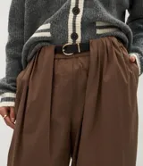 Pantalón barrel de algodón color marrón, con cintura alta, pliegues delanteros, perneras amplias y bajo afinado, diseñado con presillas y un cinturón incluido.