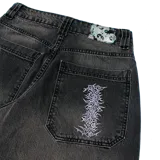 Pantalón jean baggy de denim color gris oscuro con lavado localizado, tiro medio y calce suelto. Presenta bordados en el bolsillo pequeño delantero y en los bolsillos traseros.