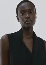 Vestido corto negro sin mangas, con cuello en V, diseño recto, bajo asimétrico y un fino cinturón incluido.