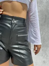 Short de tiro alto confeccionado en ecocuero elastizado, con bolsillos frontales amplios con cierre metálico.