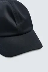 Gorra de seis paneles confeccionada en tejido de algodón, color negro, con visor curvado.