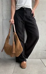 Pantalón negro de lino con pinzas en la cintura, cordón ajustable y corte wide leg.