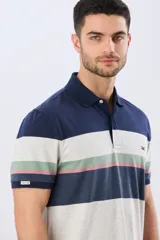 Remera polo de manga corta con diseño de franjas horizontales en tonos azul, beige, verde y terracota. Presenta cuello camisero con cierre frontal de dos botones y un pequeño bordado en el pecho.