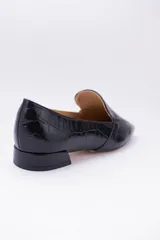 Mocasines bajos de cuero negro con textura croco y suela plana.