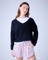 Sweater negro de cashmere cepillada con cuello en V, corte oversize, mangas largas y terminaciones acanaladas.
