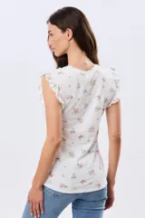 Remera blanca de algodón con delicado estampado floral y volados en las mangas cortas, con diseño de cuello redondo.