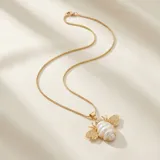 Cadena de eslabones finos con baño de oro y dije en forma de abeja con cuerpo de perla y detalles dorados.