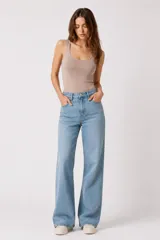 Pantalón jean de tiro alto y corte flare, color azul claro, con bolsillos delanteros y traseros.