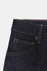 Jeans de tiro bajo con corte barrel leg y diseño de cinco bolsillos. Presenta costuras laterales curvadas con pespuntes a contraste y cierre frontal con cremallera y botón.