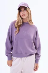 Buzo tipo canguro de felpa con efecto lavado, color violeta, con capucha, bolsillo frontal tipo canguro y mangas largas con puños ajustados.