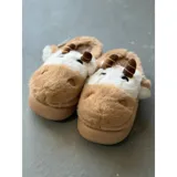 Pantuflas de peluche con diseño de vaca, confeccionadas en piel sintética suave. Cuentan con suela de goma antideslizante y diseño abierto en el talón.