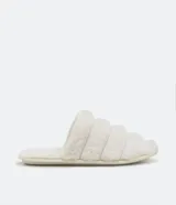 Pantufla cerrada de diseño acolchado con gajos, confeccionada en tejido de textura felpuda suave, con suela de goma termoplástica.