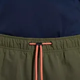 Pantalón jogging color verde oliva confeccionado en nylon reciclado con tecnología DWR (Durable Water Resistance). Cuenta con cintura y puños elásticos, cordón de ajuste naranja, dos bolsillos laterales abiertos y un bolsillo con cierre en la parte superior.