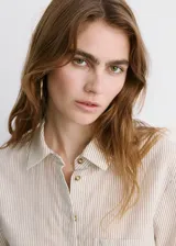Camisa de manga corta con diseño a rayas, cuello camisero, silueta regular, largo crop, bolsillo tipo parche en el frente y cierre de botones.