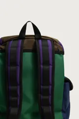 Mochila multibolsillos de diseño colorblock en tonos verde, azul marino, marrón y violeta, con solapa frontal y cierre de hebilla ajustable.
