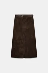 Falda midi de tejido efecto ante en color marrón oscuro, con tiro medio, trabillas en la cintura y cinturón ajustable con hebilla metálica. Presenta un diseño de bajo recto con una abertura frontal central y cierre lateral con cremallera oculta.