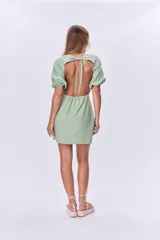 Vestido corto verde de lino, con escote cuadrado, mangas abullonadas cortas y corte recto.