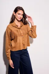 Camisa color camel de gamuza sintética, corte al cuerpo, con flecos en el pecho y mangas largas.