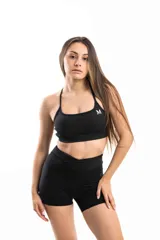 Top deportivo blanco con breteles finos y logo pequeño en el frente.