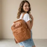 Mochila de eco-cuero negro con compartimentos múltiples, bolsillos frontales con cierre y asas ajustables.