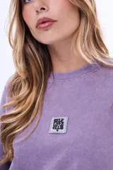 Buzo de felpa con cuello redondo a la base, de corte holgado y mangas tres cuartos con terminación desflecada. Presenta un acabado efecto lavado en color marrón.