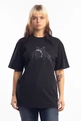 Remera de algodón color negro, con cuello redondo y mangas cortas. Presenta un estampado frontal con una estrella azul y un delfín en el centro, acompañado de tipografía estilo gótico.