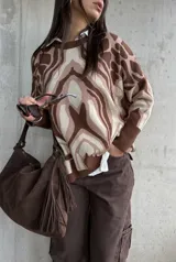 Sweater de tejido de punto con diseño estampado abstracto en tonos marrones y beige, de corte oversize, cuello redondo y mangas largas con puños acanalados.