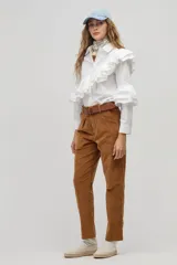 Camisa blanca de algodón con cuello clásico, cierre frontal de botones y volados dobles que recorren el frente, la espalda y las mangas.