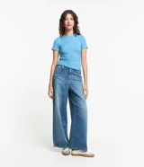 Blusa básica de manga corta y cuello redondo, confeccionada en viscosa texturizada de canalé con elastano y detalle de terminación ondulada en el bajo.