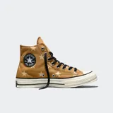 Championes Converse Chuck 70 de caña alta, color marrón con estampado de estrellas en tono crema. Presentan puntera de goma blanca, cordones negros y el icónico parche circular de la marca en el lateral.