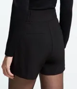 Bermuda roja de poliéster con cintura elástica, bolsillos laterales y cierre con cremallera y botones.