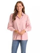 Camisa blanca de la marca Liv Los Ángeles, con cuello con solapa y cierre frontal de botones. Presenta mangas largas con detalles calados y puños anchos con botones.