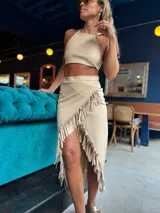 Top beige con cuello halter y espalda descubierta.