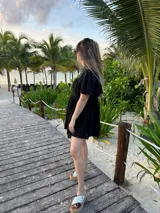 Vestido corto color beige de lino, con cuello mao, mangas cortas con volados, tablas en el canesú y falda escalonada con volantes.