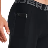 Calza deportiva corta Under Armour de compresión, color negro, con cintura elástica ancha con la marca impresa y logo de la marca en el muslo derecho.