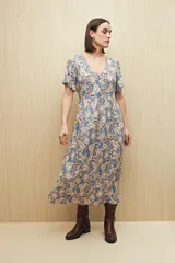 Vestido largo celeste con estampado floral en tonos beige y marrón, escote en V con botones al frente, mangas cortas y falda con leve vuelo. Confeccionado en viscosa liviana.
