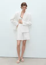 Short de tiro alto confeccionado en tejido de algodón estilo denim, con diseño recto, cierre frontal de cremallera y botón, trabillas para cinturón y cinco bolsillos.