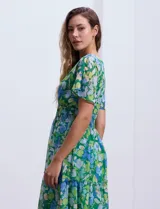 Vestido largo de gasa estampada con flores en tonos verde y azul, escote en V delantero y trasero, corte en la cintura con punto smock y mangas cortas.