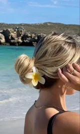 Broche para el pelo con forma de flor de hibisco color blanco con centro amarillo.