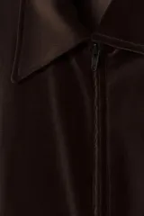 Cazadora de terciopelo de algodón color marrón oscuro, con cuello solapa, cierre frontal de cremallera y bolsillos frontales de vivo. Presenta rib elástico a tono en puños y bajo.