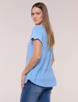 Blusa celeste de tejido pointelle calado, con escote redondo, mangas cortas con dobladillo y presilla con botón, y ruedo curvo.