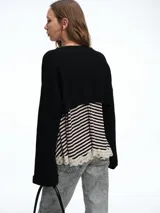 Sweater de punto en color gris, con diseño crop de mangas largas y cuello bote. Presenta una textura acanalada y un corte moderno que permite superposiciones.