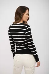 Suéter de punto ajustado, color negro con rayas horizontales blancas. Presenta cuello redondo y mangas largas con puños ajustados.