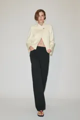 Jeans de tiro medio color negro, de corte recto y largo completo, con diseño clásico de cinco bolsillos, trabillas para cinto y cierre frontal con cremallera y botón.