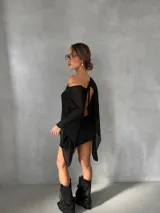 Vestido corto negro de diseño asimétrico con un hombro al descubierto. Presenta mangas largas acampanadas de tela semitransparente y una falda ajustada al cuerpo.
