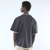 Camiseta de manga corta en color negro con diseño de efecto 2 en 1, presentando bordes en color blanco en el cuello, mangas y ruedo inferior.